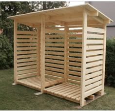 a wooden structure sitting on top of a lush green field