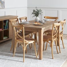 a dining room table with chairs and plates on it