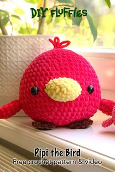 a crocheted bird sitting on top of a window sill next to a potted plant