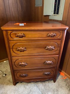 a wooden dresser sitting in front of a mirror