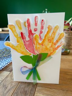 a card with handprints on it sitting on a table