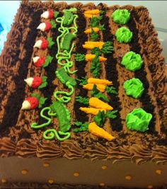 a chocolate cake with green frosting and vegetables on it