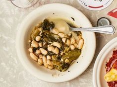 a white bowl filled with beans and greens