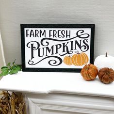 a sign that says farm fresh and pumpkins next to two small pumpkins on a mantel