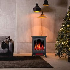 a living room with a couch, fireplace and christmas tree in the corner next to it