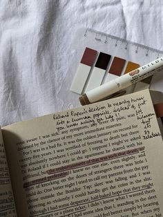 an open book sitting on top of a table next to a ruler and pen with writing on it