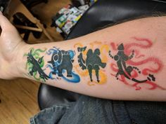 a man's arm with different colored tattoos on it