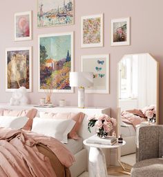 a bedroom with pink walls and white furniture in the corner, along with a large mirror on the wall