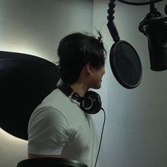 a man wearing headphones sitting in front of a microphone