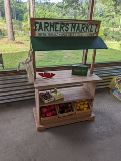 a farmers market stand with fruits and vegetables on display in front of a large window