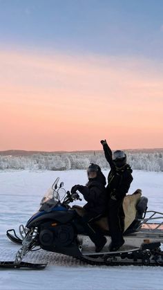 two people riding on a snowmobile in the snow