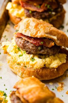 breakfast sandwiches with eggs, bacon and cheese on croissants are ready to be eaten