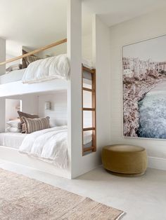 a bedroom with two bunk beds and a large painting on the wall above it's headboard