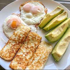 an egg, toast, and avocado are on a plate with some bread