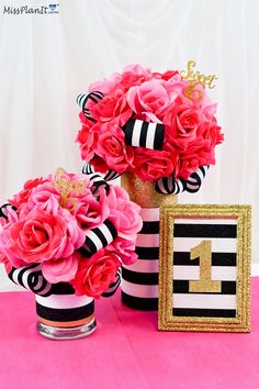 two vases filled with pink flowers on top of a table