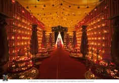 an elaborately decorated room with lots of lights on the ceiling and tables set up in rows