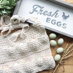 an egg tray with eggs and a crochet bag next to it on a wooden table