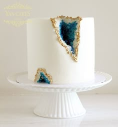 a white cake with blue and gold decorations