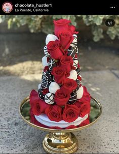 a three tiered cake decorated with red roses