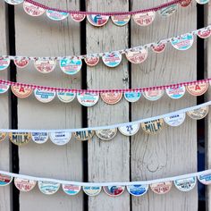 some paper hearts are hanging from a string on a fence with red and white checkered ribbon