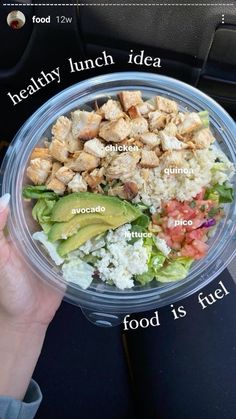 a person holding a plastic bowl filled with food and labeled parts of the meal in it