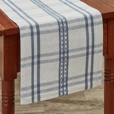 a wooden table topped with a white and blue checkered table cloth on top of it