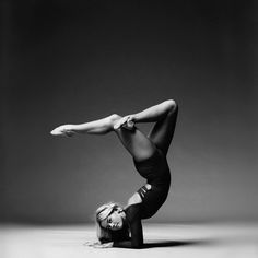 a woman is doing a handstand on the floor with her legs spread out