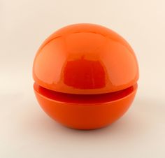 an orange plastic container sitting on top of a white table