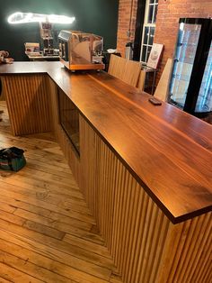 a wooden counter top sitting in the middle of a room next to a brick wall