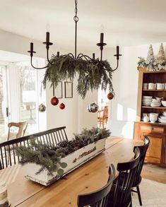 a wooden table topped with a planter filled with greenery