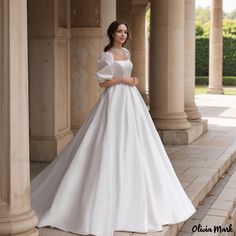 a woman in a white wedding dress posing for the camera with her hand on her hip