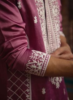 The chittorgarh kurta in raspberry is a vibrant addition to any Indian groom's wardrobe, ideal for haldi, mehndi, or sangeet celebrations. Crafted from luxurious viscose cotton silk, this kurta offers a smooth, breathable feel that's perfect for festive occasions. Paired with an ivory salwar, this ensemble offers a harmonious and refined look. The chittorgarh kurta is perfect for grooms who appreciate traditional craftsmanship with a contemporary twist. Pair it with traditional or modern footwear for a complete and polished appearance. Indian Groom, Bespoke Tailoring, Vintage Rose, Vintage Roses, Cotton Silk, Raspberry, Twist, Embroidery, Silk