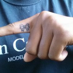 a man with a bow tattoo on his finger