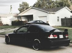 a black car parked in front of a house