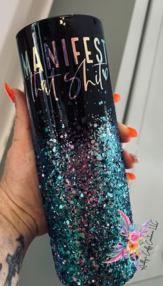 a woman holding up a black and blue glitter tumbler with the words nannies that slay on it