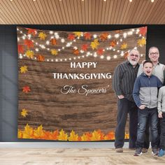 a group of people standing next to each other in front of a happy thanksgiving sign