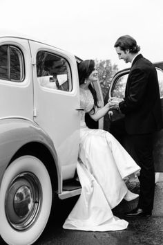 a bride and groom getting out of an old car