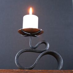 a white candle sitting on top of a wooden table