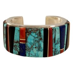 A Bisbee turquoise, lapis, coral, wood, 14 yellow karat gold and sterling silver height inlay cuff. Signed E. Cummings, Stamped 14k. 5.5" terminal-to-terminal plus 1" opening. Cummings was born in 1962 in White Cone, Arizona. He studied painting and sculpture at the Institute of American Indian Arts in Santa Fe. While pursuing a degree in art education at Arizona State University, Cummings began to study metalsmithing and jewelry. Cumming’s silver work is typified by excellent craftsmanship and Native American Jewellery, Indian Arts, Bisbee Turquoise, Artistic Wallpaper, Inlay Jewelry, Snake Ring Silver, Big Jewelry, Turquoise Jewelry Native American, Antique Bracelets