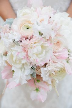 a bridal holding a bouquet of white and pink flowers