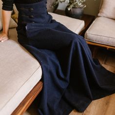 Elevate your winter wardrobe with our High Waisted Wool Maxi Skirt, crafted from luxurious cool wool for a sophisticated touch. This timeless piece features an extra-high waist adorned with stylish buttons, convenient pockets for added functionality, and a floor-length silhouette that effortlessly combines comfort and elegance, making it a versatile addition to any fashion-forward ensemble.  Enjoy the effortless fit and the feminine sense when wearing our creations! Every piece by NikkaPlace is Stylish Buttons, Wool Maxi Skirt, Empire Waist Maxi, Elegant Coats, Skirt With Buttons, Tie Skirt, Fantasy Gowns, Full Circle Skirts, Wool Skirt