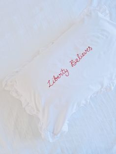 an embroidered pillow with the words i love my brother on it, laying on a bed