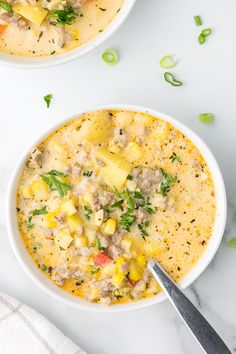 two white bowls filled with soup on top of a table next to a knife and napkin