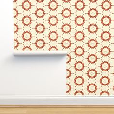 an orange and white wallpaper pattern on the side of a room with wood flooring