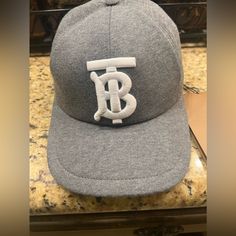 *New* Men’s Authentic Burberry Cap Tb Monogram Motif Jersey Cap Dark Charcoal All Tags Attached. *Never Worn-New* Designer Baseball Cap With Short Brim, Designer Baseball Cap With Adjustable Short Brim, Designer Adjustable Baseball Cap With Short Brim, Luxury Curved Brim Baseball Cap, Luxury Hats With Logo Patch And Curved Brim, Luxury Snapback Hat With Embroidered Logo, Luxury Flat Brim Baseball Cap With Embroidered Logo, Luxury Baseball Cap With Embroidered Logo And Flat Brim, Classic Cap With Logo Detail