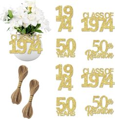 the numbers are made out of gold glitter and have white flowers in a vase with twine