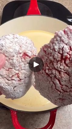 two powdered sugar donuts being fried in a skillet