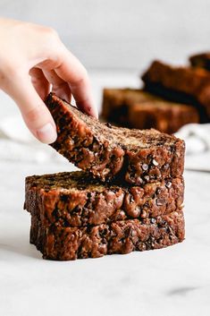 a person is picking up some brownies from the stack on top of each other