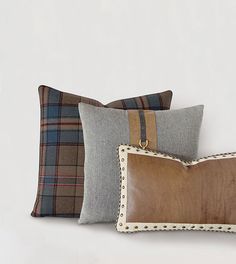 three pillows with different colors and designs on them, one is brown the other is gray