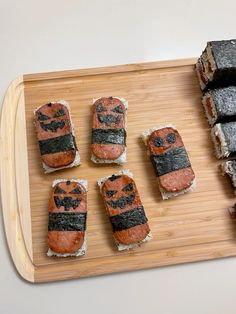 sushi on a wooden cutting board with different types of sushi